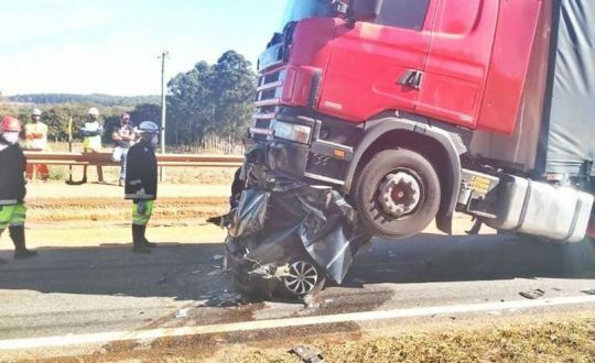 Carro vira bola de metal embaixo de caminhão e sogro e genro morrem